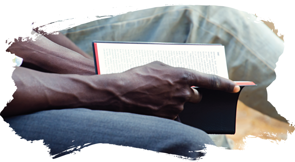 a closeup of an open Bible being held by a man's hands 